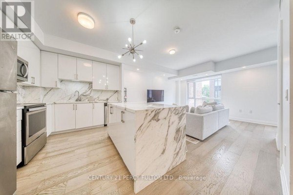 Modern kitchen with white cabinetry, marble island, and living area. - D-803 - 5289 Highway 7, Vaughan