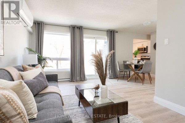 Living area and dining area with grey chairs, glass table, and kitchen in background. - D1 - 240 Ormond Drive, Oshawa