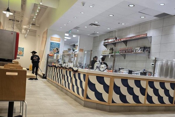 PokeWorks service counter with employees, food displays, and shelving above. - D1-b - 2465 Appleby Line, Burlington