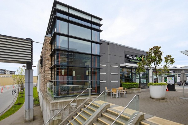 Exterior view of the commercial building with a glass tower, stairs, and patio seating. - D130 3122 Mt. Lehman Road, Abbotsford