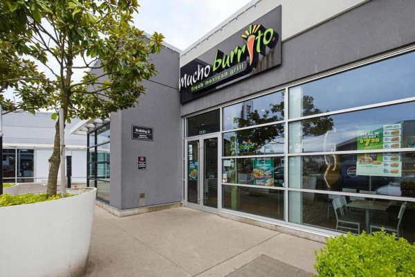 Macho Burrito storefront entrance with adjacent building signage and a large planter. - D130 3122 Mt. Lehman Road, Abbotsford