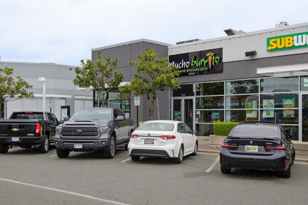 Parking lot in front of commercial units including Mucho Burrito and Subway with parked vehicles. - D130 3122 Mt. Lehman Road, Abbotsford