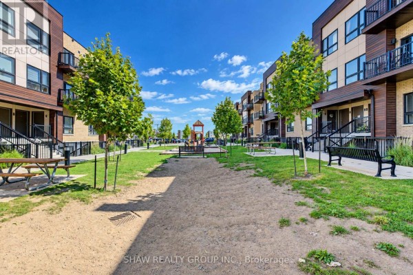 Path through a park-like area with sandpit, picnic tables, benches, and playground equipment. - D16 - 10 Palace Street, Kitchener