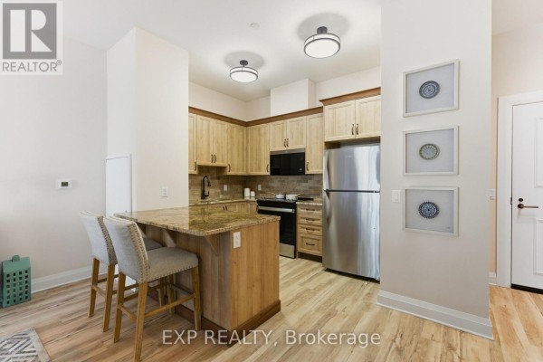Kitchen with breakfast bar, stainless steel appliances, and wooden cabinetry - D217 - 277 Coleman Street, Carleton Place