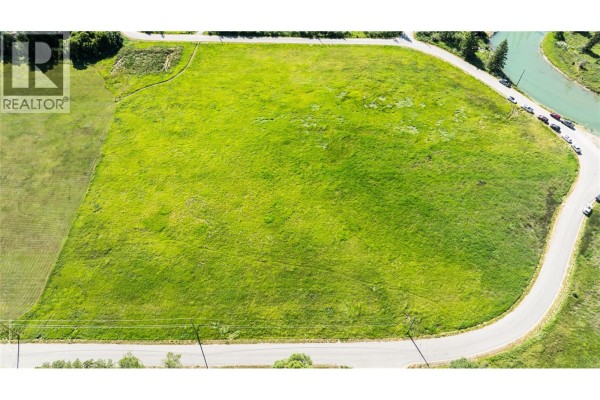 Aerial view of a large, cleared, green lot with a curved road and river. - Downey Road Lot# Lot 26, Fairmont Hot Springs