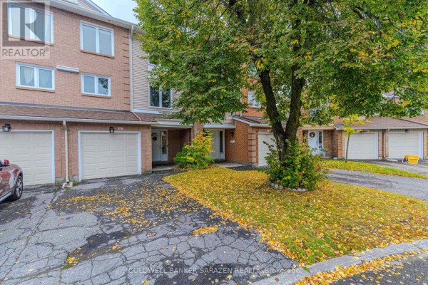 Driveway with fallen leaves leading to townhouse garages and entrances. - E - 6 Millrise Lane, Ottawa