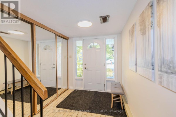 Interior foyer with white door, large mirrored closet, and artwork on wall. - E - 6 Millrise Lane, Ottawa