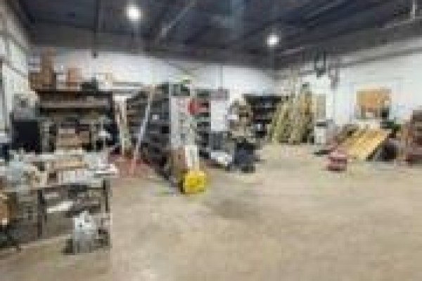 Interior view of a warehouse space with storage shelves and various equipment. - E - 866 Phillip Street, Sarnia