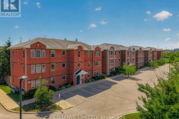Side view of the townhouse complex with parking area and landscaped surroundings - E-202 - 59 Arch Brown Court, Barrie