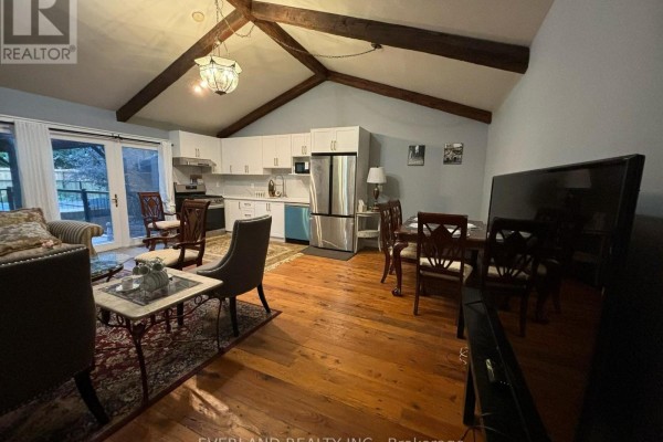 Dining area and kitchen with white cabinets, stainless steel appliances, and French doors to the outside. - Ensuite Room - 3369 St Paul Avenue, Niagara Falls