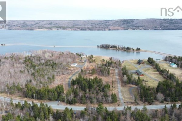 Aerial view of a coastal landscape with forested land, a road, and homes near the water. - Eskasoni Road, Northside East Bay