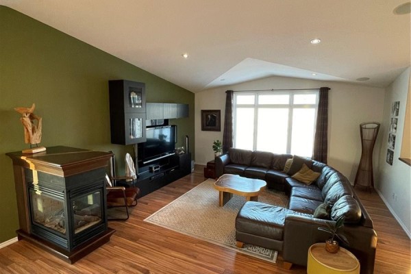 A living room with a large sectional sofa, fireplace, and entertainment center. - Etomami River Acreage 15 Acres, Hudson Bay Rm No  394