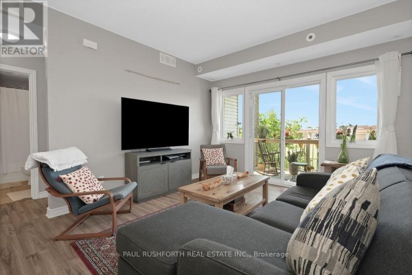 Living room with a grey sectional sofa, wood coffee table, and large windows. - F - 1105 Stittsville Main Street, Ottawa