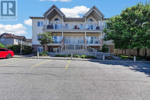 Front exterior view of apartment building with multiple balconies and a central staircase. - F - 151 Mocha Private, Ottawa