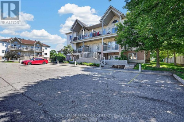 Side exterior view of apartment building showing balconies and adjacent trees. - F - 151 Mocha Private, Ottawa