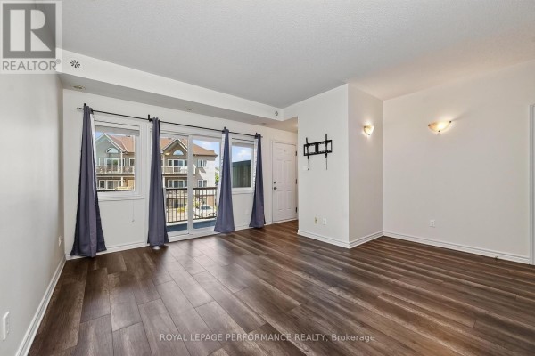 Interior living space with dark wood floors, white walls, and a patio door. - F - 151 Mocha Private, Ottawa