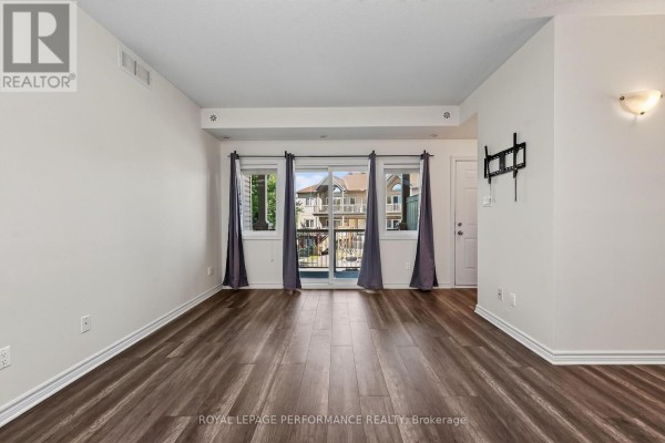Interior living space with dark wood floors, white walls, and a sliding glass door. - F - 151 Mocha Private, Ottawa