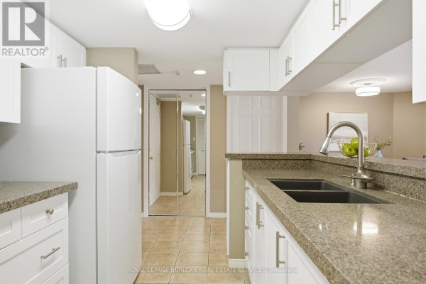 Kitchen featuring stainless steel appliances, double sink, and ample storage space. - F304 - 216 Plains Road W, Burlington