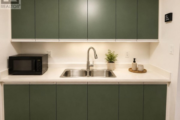 Kitchen area with a double sink, stainless steel faucet, microwave, and dark green cabinets. - F8 - 171 Edgehill Drive, Barrie