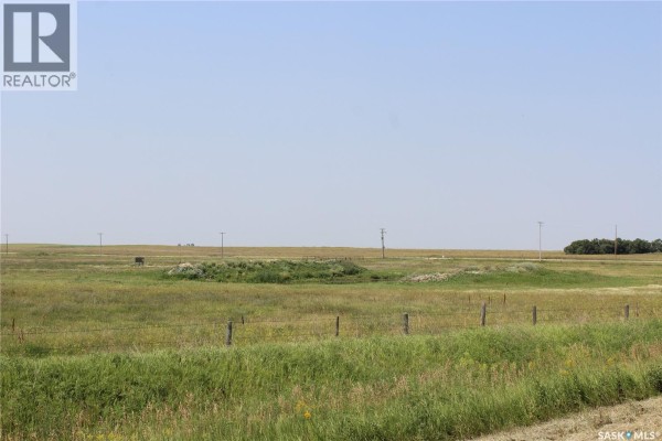 Wide view of a rural landscape featuring fields, a low structure, and utility poles under a clear sky. - Fair Farm, Coalfields Rm No  4