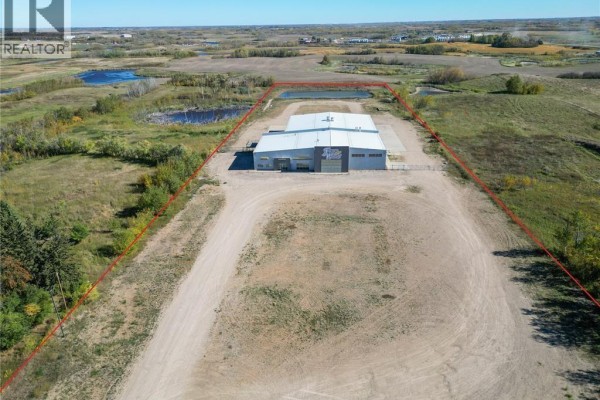 Aerial view of a commercial building situated on a large gravel lot, bordered by red lines. - Farm World Prince Albert, Prince Albert Rm No  461