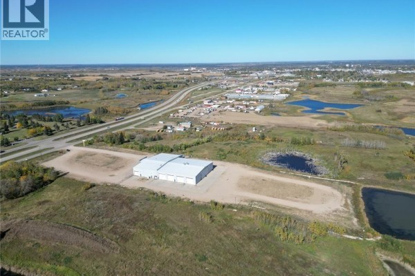 Aerial view of a commercial building with a large highway in the background and surrounding wetlands. - Farm World Prince Albert, Prince Albert Rm No  461