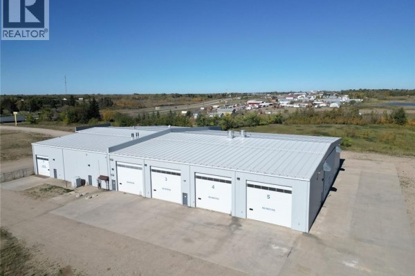 Aerial view of the rear of a commercial building showing five large garage doors labeled 1 through 5. - Farm World Prince Albert, Prince Albert Rm No  461