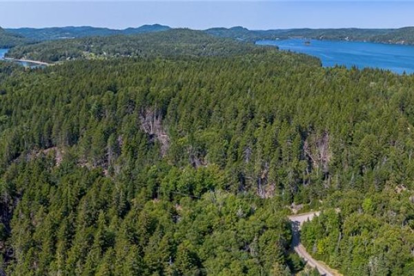 Wide aerial shot of a forested peninsula jutting into a tranquil bay with islands. - Fiander Road, Bocabec