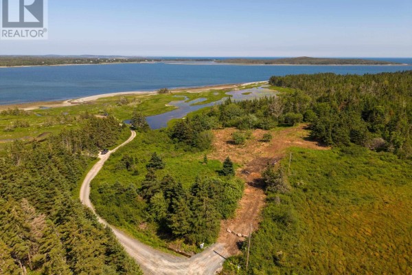 Aerial view of a property lot with a gravel road leading towards the water and surrounding trees. - Front Acre Lot Conroad Beach Road, Lower East Chezzetcook