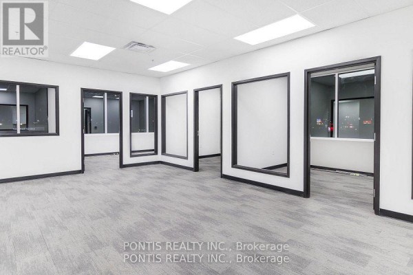 Office space with several doorways and windows showing city lights at dusk. - G206& 207 - 450 Hespeler Road, Cambridge