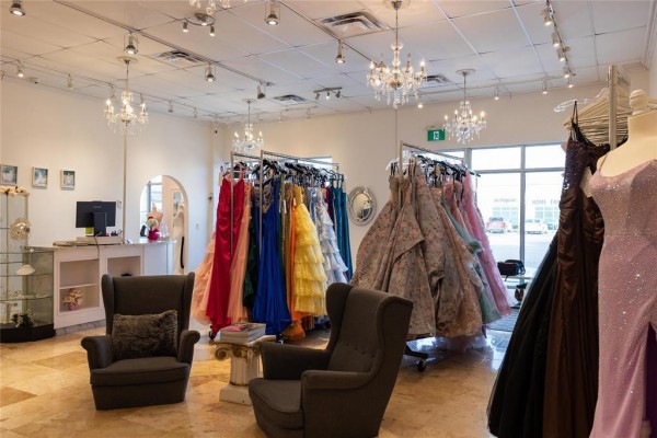 Interior of bridal boutique featuring colorful dresses and chandeliers. - G&h 197 Main Street, Steinbach