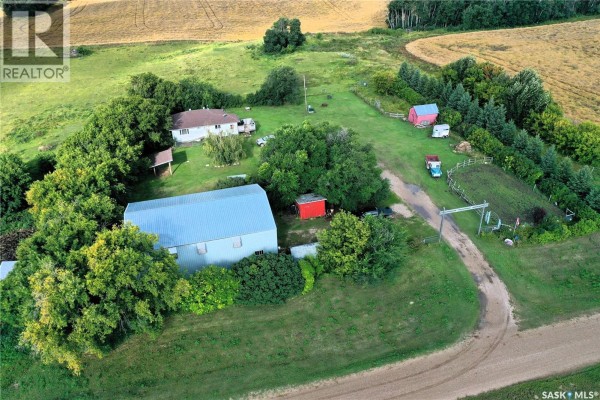 Aerial view of Grandfield Acreage showing the house, barn, and outbuildings among trees. - Grandfield Acreage, Nipawin Rm No  487