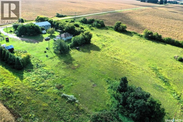 Aerial view of Grandfield Acreage with a house, barn, and expansive green fields. - Grandfield Acreage, Nipawin Rm No  487