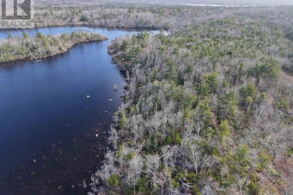 Aerial view looking over a treed lot with a dark lake in the distance and a small cove. - Granite Ridge Road, Birchtown
