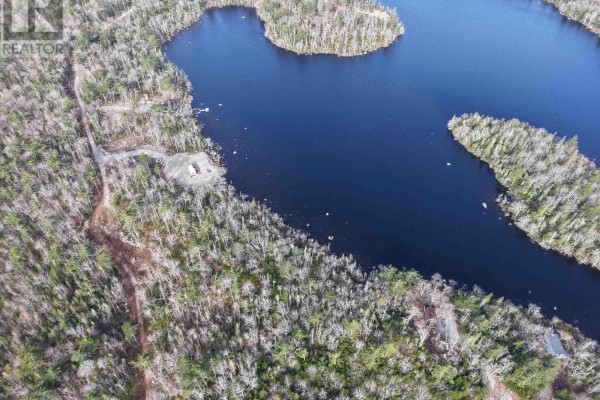 Aerial view of a lake surrounded by dense forest with a cleared area and driveway visible. - Granite Ridge Road, Birchtown