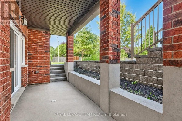 Entrance to apartment H with a white door, brick facade, and outdoor lighting. - H - 105 Fraser Fields Way, Ottawa