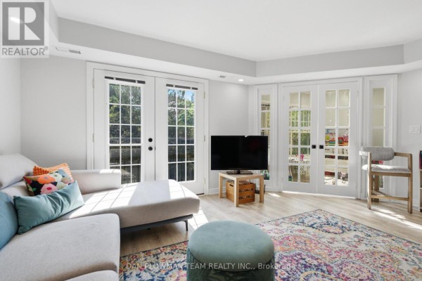 Living room sectional sofa, double doors to the yard, and French doors to another room. - H11 - 76 - 1661 Nash Road, Clarington