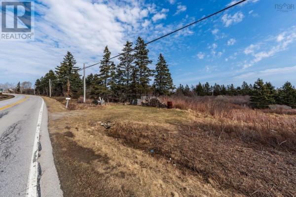 Land along the highway with trees, power lines, and a small clearing. - Highway 1, Beaver River
