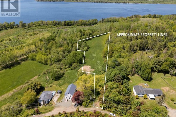 Aerial view of property lines marked on a cleared field with homes and a large body of water. - Highway 201, Moschelle