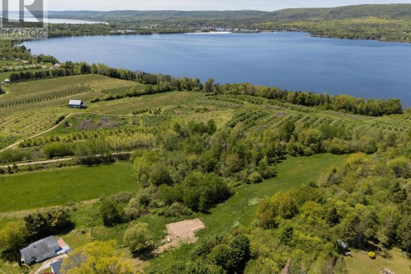 Aerial view of fields, orchards, and wooded areas bordering a large blue lake. - Highway 201, Moschelle
