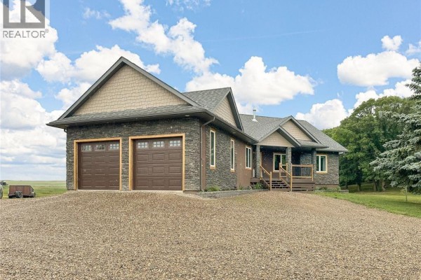 Aerial view of a large house with a deck, surrounded by green lawn and trees. - Holars Haven Acreage, Spy Hill Rm No  152