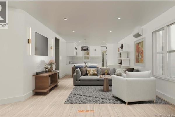 Open-concept living room with grey sofa, white armchair, wood floors, and a kitchen in the background. - Homestead Drive, Hampton