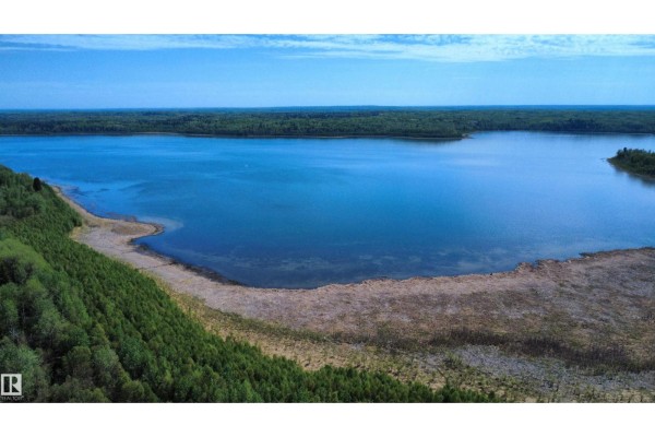 Aerial view of Hope Lake with a treed bank and clear blue sky. - Hope Lake Nw-33-65-18-w4, Rural Athabasca County
