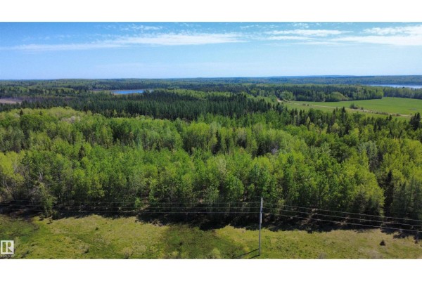 Aerial view of a dense green forest with a few power lines in the foreground. - Hope Lake Nw-33-65-18-w4, Rural Athabasca County