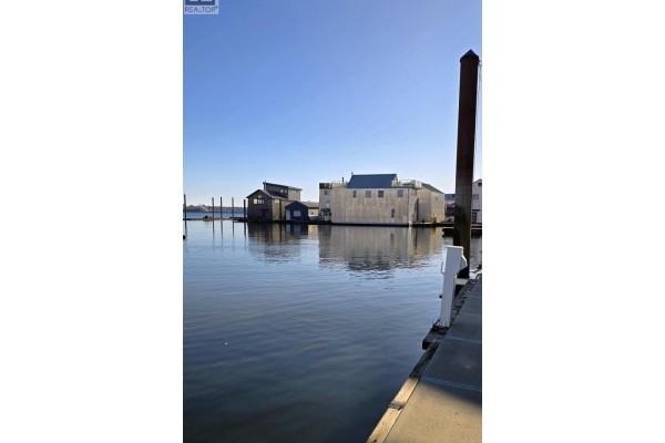 Waterfront view of buildings and docks reflecting on the still water surface. - Jnw33 415 W Esplanade, North Vancouver