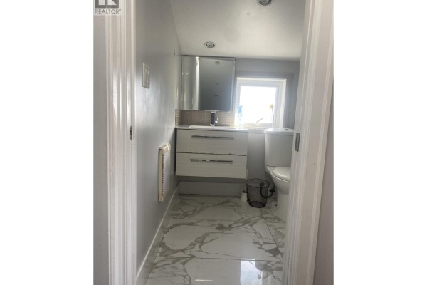 Hallway view of bathroom vanity, toilet, and window. - Laneway House 3436 Tanner, Vancouver