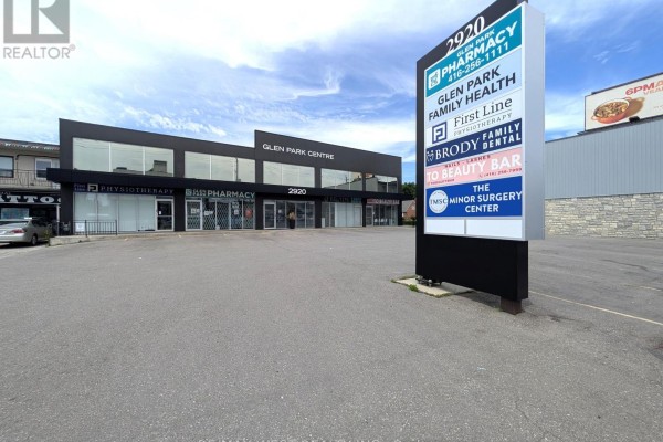 Exterior view of the commercial building with a prominent multi-tenant pylon sign. - Ll2 - 2920 Dufferin Street, Toronto