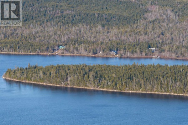 Aerial view from the tip of a wooded island, looking across dark water towards the mainland. - Long Pt Lawrencetown, Seaforth