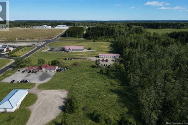 Aerial view of a commercial area with snow-dusted parking lots, buildings, and surrounding land. - Lot 06-1 Burnham Road, Florenceville Bristol