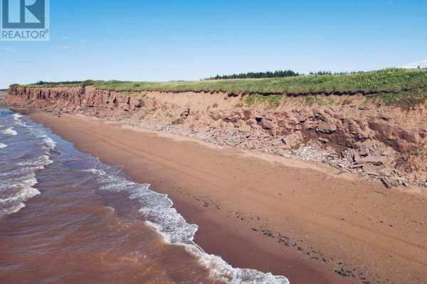 Beachfront view of red cliffs and sandy shore along the coastline. - Lot 06-1 Route 14, Campbellton